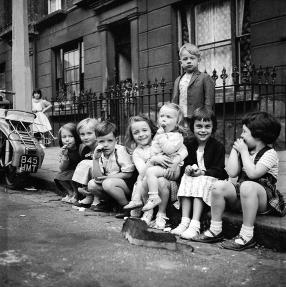 Children sitting on the curb, Maida Vale: 1960