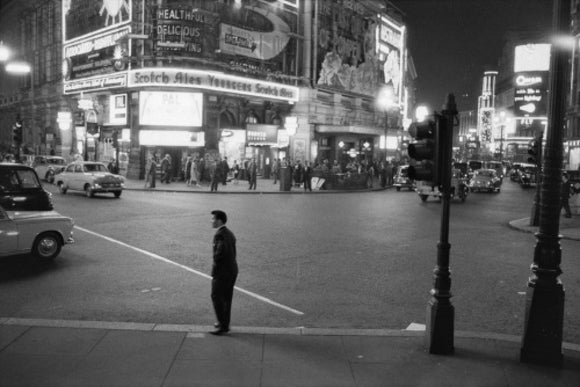 Lone man in Piccadilly at night; 1960