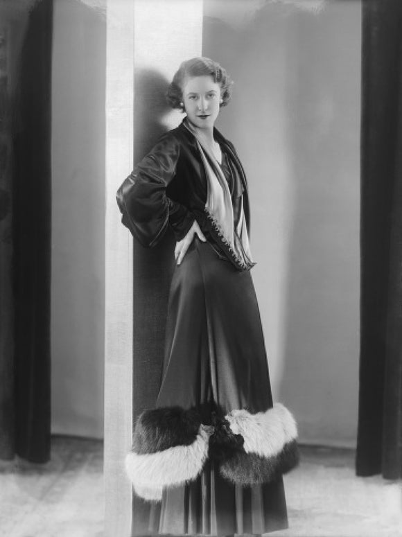 Image of a woman modeling a an evening coat; 1932